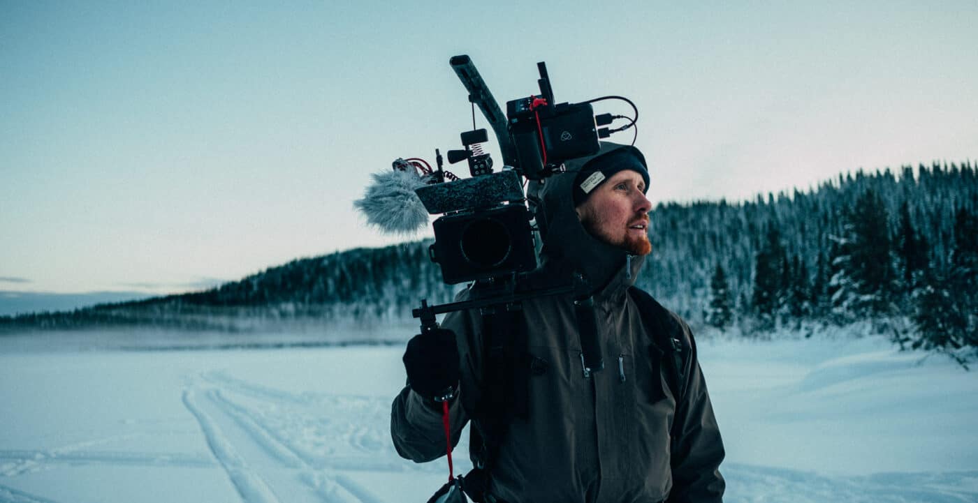Johan Nyström med filmutrustning i ett vinterlandskap i Åre.